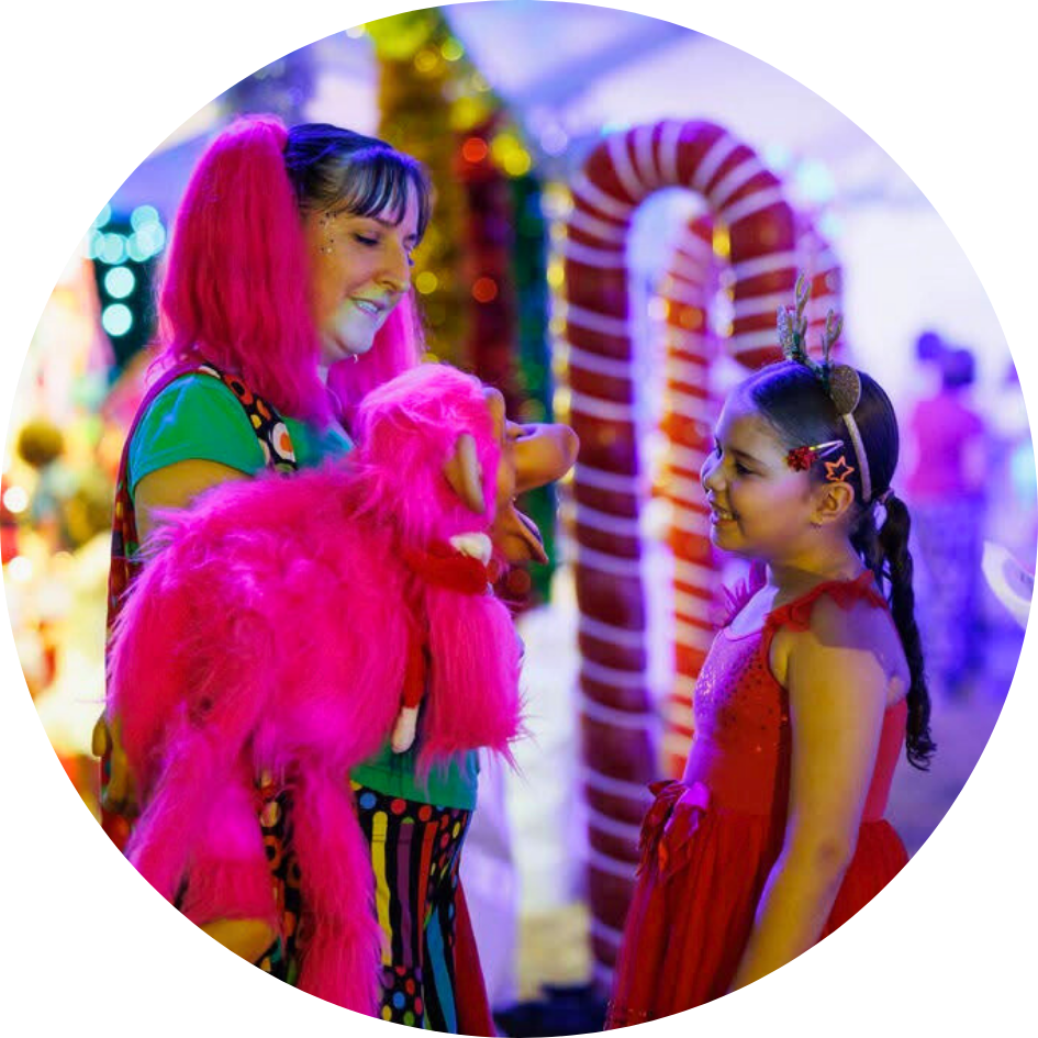 Hyper the Clown and her puppet Pinky have a conversation during a Christmas roving entertainment event in Darwin.